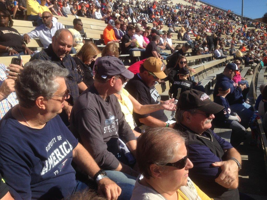 A group of people sitting in the stands at an event.