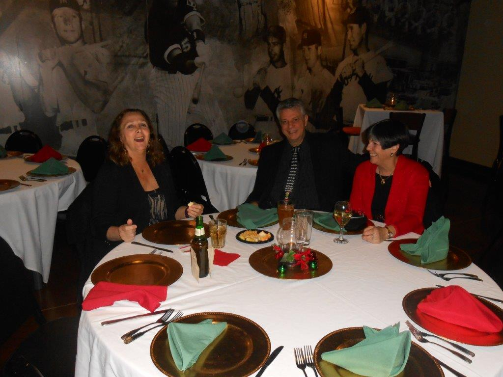 A group of people sitting at a table with plates and silverware.