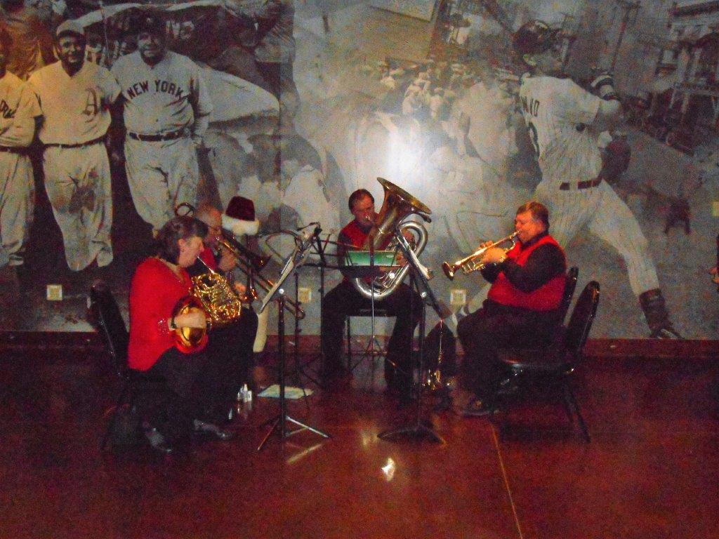 A group of people playing instruments in front of a wall.