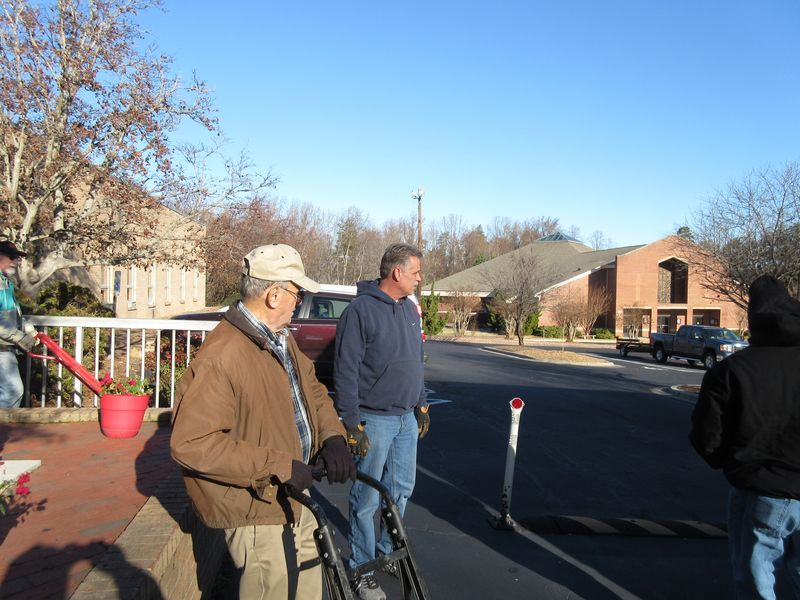 Two men standing on the side of a road.